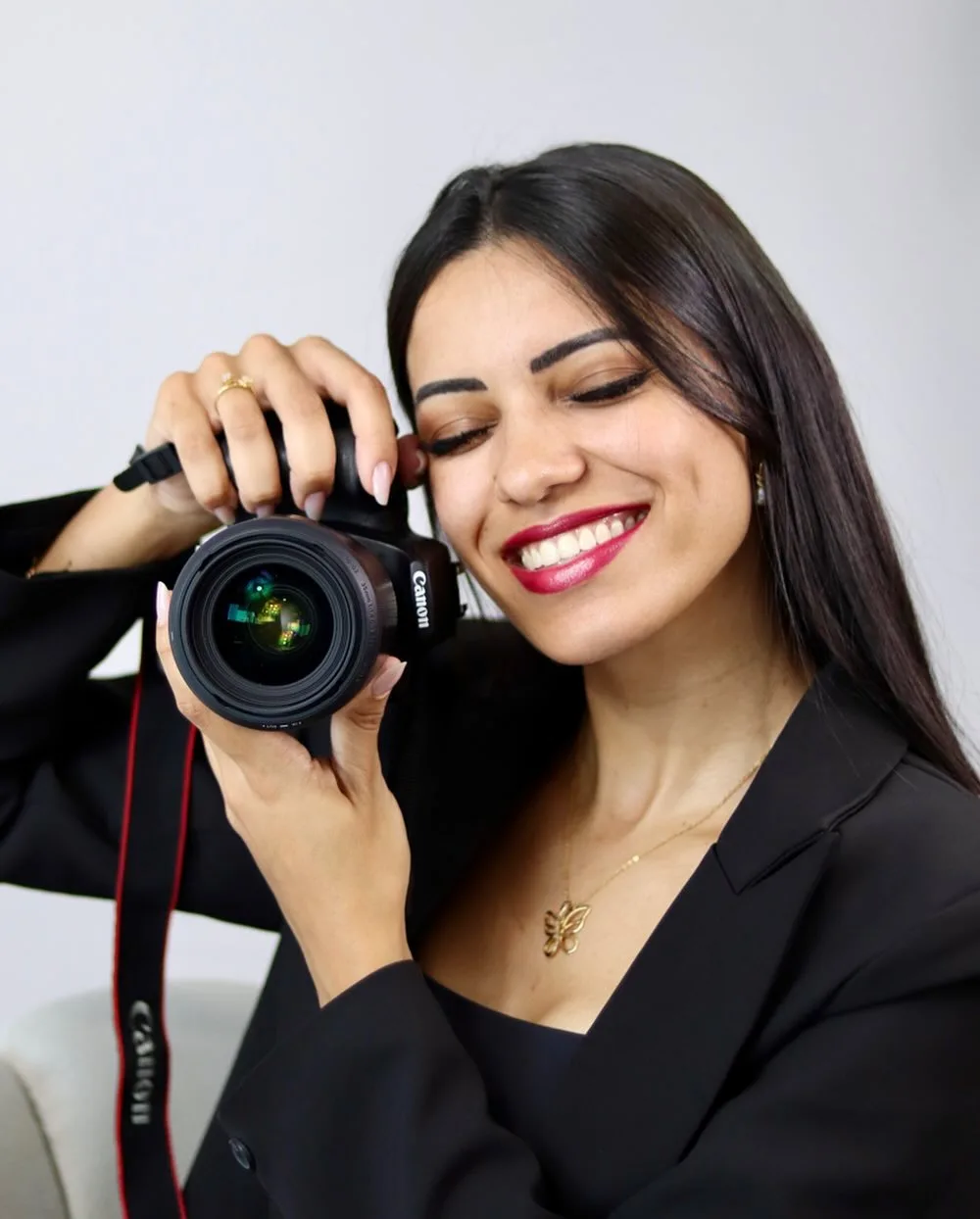 Gabriela Rocha sorrindo enquanto segura uma câmera